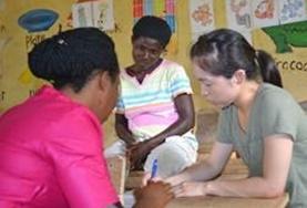 Volunteer Language Courses A volunteer works through an activity with her Ga language tutors.