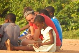Volunteer Care An adult volunteer works on a child's reading skills at a care centre during our Care & Community project in Ghana.
