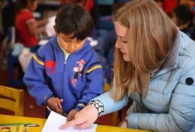 Volunteer Care A childcare volunteer guides a child through his homework at our Care & Community placement in Peru.