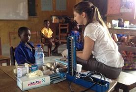 Volunteer Medicine and Healthcare A volunteer in Ghana takes basic measurements to check the general health of a child during a Public Health screening outreach.