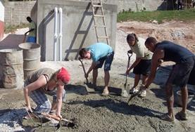 Volunteer Jamaica Building volunteers in Jamaica mix cement during the construction of a new house.