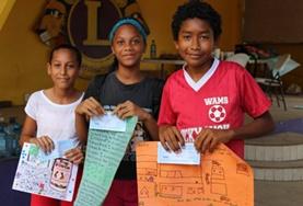 Volunteer Belize Local children in Belize show off posters they made for a project at one of our Care placements.