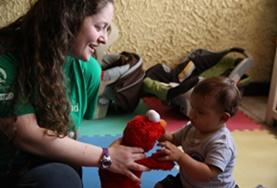 Volunteer Care A volunteer plays with a child using a soft toy at our Care placement in Costa Rica.
