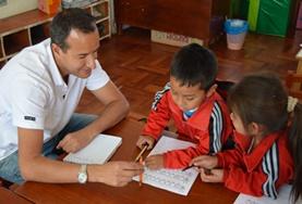 Volunteer Care A volunteer provides support for children as they finish their homework at one of our childcare placements at a school in Peru.