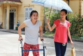 Volunteer Vietnam A Care volunteer works with a disabled child in Vietnam, helping her to walk and exercise.