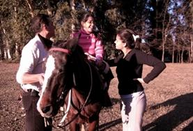 Volunteer Care An Equine Therapy volunteer in Argentina speaks to a child before starting a treatment session with her therapy horse.