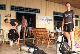 Volunteer Cambodia Diving & Marine Conservation volunteers prepare for a survey dive in Cambodia by setting up their scuba equipment.