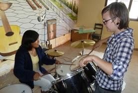 Volunteer Bolivia A Music volunteer teaches a local child how to play the drums during a music therapy session in Bolivia.