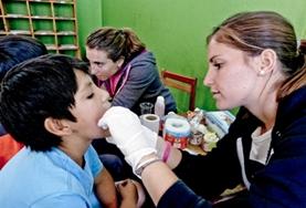 Volunteer Medical Electives A Medicine Elective intern examines a child during a screening outreach in Peru, South America.
