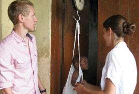 Volunteer Ghana A midwifery student assists with weighing a baby at his volunteer elective placement in a Ghanaian health clinic.