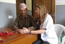 Volunteer Nepal A volunteer on her Physiotherapy Elective works on stretches to improve fine motor coordination for a local man in Nepal.