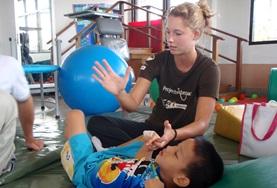 Volunteer Physiotherapy An intern doing her Physiotherapy Elective in a developing country works on mobility exercises with a disabled child.