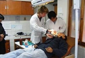 Volunteer Medicine & Healthcare A Dentistry volunteer assists while a dentist examines a patient's teeth at a hospital in Peru.