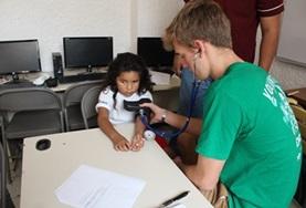 Volunteer Medicine & Healthcare A Medicine volunteer measure a child's blood pressure during a healthcare outreach in Mexico.