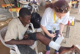 Volunteer Medicine & Healthcare A Medicine volunteer assists with dressing a patient's wound during her internship in Togo.