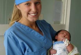 Volunteer Medicine & Healthcare A Midwifery intern volunteering in the maternity department of a Mongolian hospital holds a newborn baby.