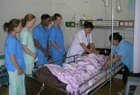 Volunteer Mongolia Nursing interns in Mongolia observe as local doctors insert an IV into a patient as part of her treatment.