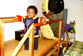 Volunteer Medicine & Healthcare A young child at our volunteer Physiotherapy placement in Ethiopia uses bars to support himself as he exercises his legs.