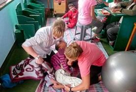 Volunteer Medicine & Healthcare Two Physiotherapy volunteers work together to treat a disabled child during their internship in Nepal.