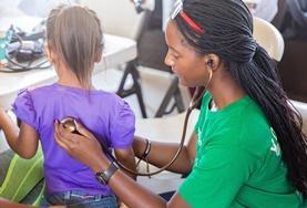 Volunteer Nursing A Nursing volunteer checks a child's heart rate as part of her medical internship abroad.