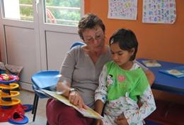 Volunteer Care A professional social worker reads a book with a young child as part of her volunteer work at a daycare centre in Romania.