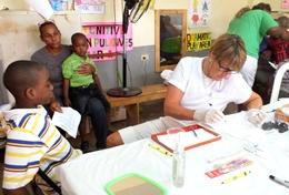 Volunteer Medicine & Healthcare A qualified dentist examines children's teeth during a dental outreach at her volunteer placement in Jamaica.
