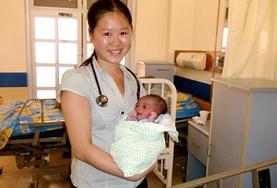 Volunteer Medicine & Healthcare A qualified Midwife holds a baby she helped deliver at her volunteer placement in a Jamaican hospital.