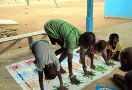 Volunteer Medicine & Healthcare Local children in Ghana work through a therapy technique to improve their daily functioning with the help of a professional occupational therapy volunteer.