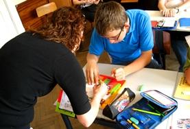 Volunteer Medicine & Healthcare A professional Occupational Therapist volunteering in Romania works with a disabled child on an art project to improve his fine motor skills.