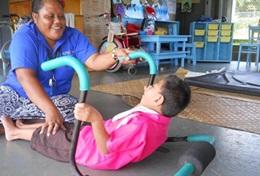 Volunteer Medicine & Healthcare A professional physiotherapist helps a disabled child through a specialised therapy exercise at her volunteer placement in Samoa.