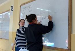 Volunteer Teaching A qualified maths teacher volunteering in Peru works through a maths problem with a school student.