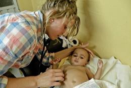 Volunteer Medicine & Healthcare A professional medical volunteer helps with treating a child at a hospital in a developing country.