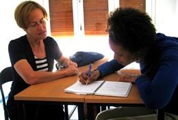 Volunteer Teaching A professional teacher works closely with a school student as part of her volunteer project abroad.