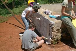 Volunteer Building High School Special Building volunteers cover a brick wall with cement in a local community in Jamaica.