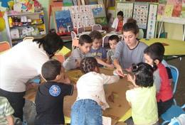 Volunteer Care A high school student volunteering in Morocco runs an educational activity with children, under the guidance of a local teacher.