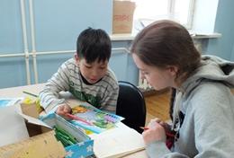 Volunteer Care A High School Special volunteer works closely with a local child in Mongolia to improve his reading and literacy skills.