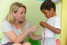 Volunteer Social Work A Social Work volunteer leads a young boy through an activity during her internship in Ecuador.