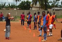 Volunteer Togo A volunteer works with a local football team in Togo, leading them through a drill to improve their ball skills and technique.