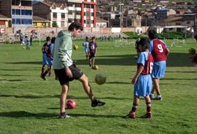 Volunteer Sports A Sports volunteer teaches school children his technique for kicking a football on our Multi-sports project in Peru.