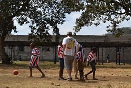 Volunteer Tanzania A volunteer coaches a group of students during a school sports lesson in Tanzania.