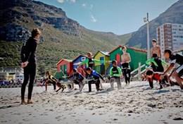 Volunteer South Africa A volunteer works with local children on their surfing technique during a lesson in South Africa.