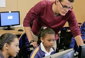 Volunteer Teaching A Teach IT volunteer demonstrates important computer skills to a young girl at a school in South Africa.