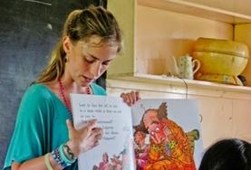 Volunteer Fiji A Teaching volunteer points to the words as she reads an English book to school children in Fiji.