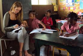 Volunteer Jamaica A volunteer works closely with local school children during an English language lesson on our Teaching project in Jamaica.