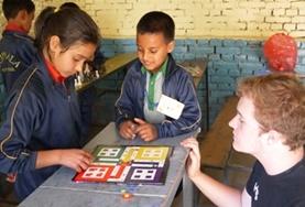 Volunteer Nepal A Teaching volunteer uses a board game to teach school children about colours and numbers at a local school in Nepal.
