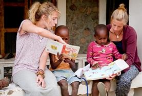 Volunteer Tanzania Teaching volunteers read English books with local children in Tanzania to improve their literacy skills.